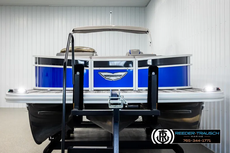 Slide: The Image of 2025 Bennington LTFBSE pontoon boat in showroom, blue exterior, Reeder-Trausch Marine. - 8