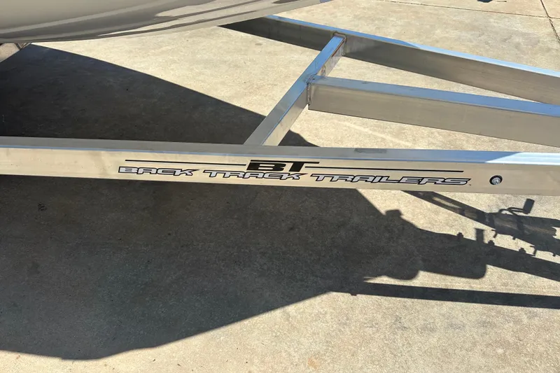 Slide: The Image of 2026 Xpress H20B Bay boat on trailer, parked outdoors in a sunny setting. - 14