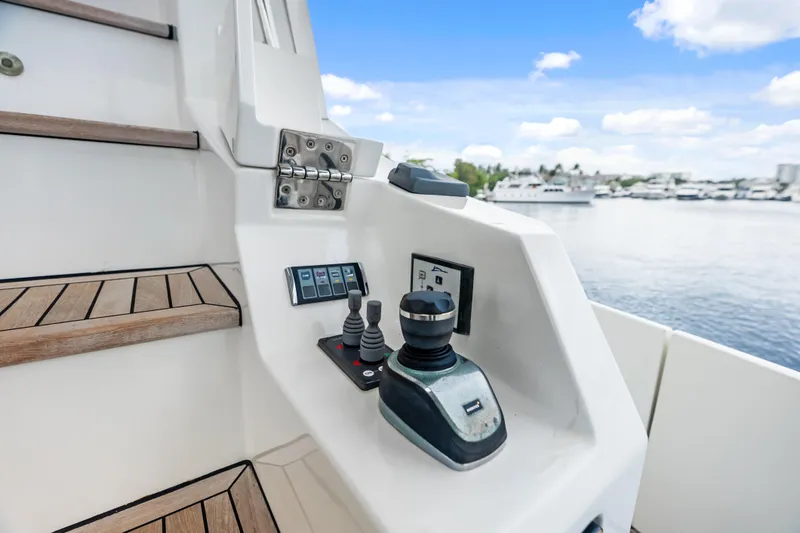 Slide: The Image of Control panel on 2017 Azimut Fly 72 yacht, featuring joystick and digital display by wooden steps. - 53