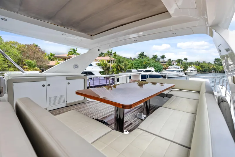 Slide: The Image of Luxurious 2017 Azimut Fly 72 yacht deck with elegant seating and table, docked by waterfront. - 67