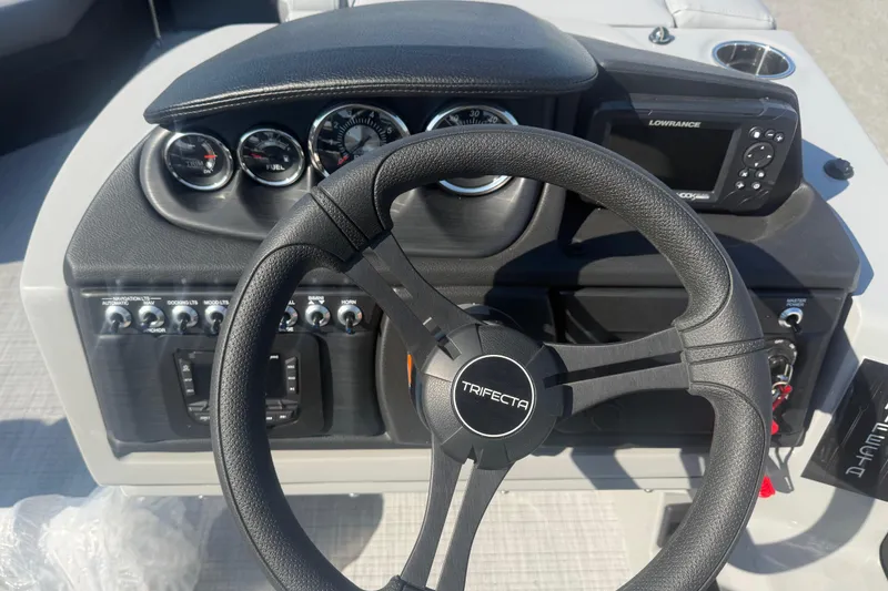 Slide: The Image of Steering wheel and dashboard of 2026 Trifecta 22ULCS boat with gauges and controls. - 12