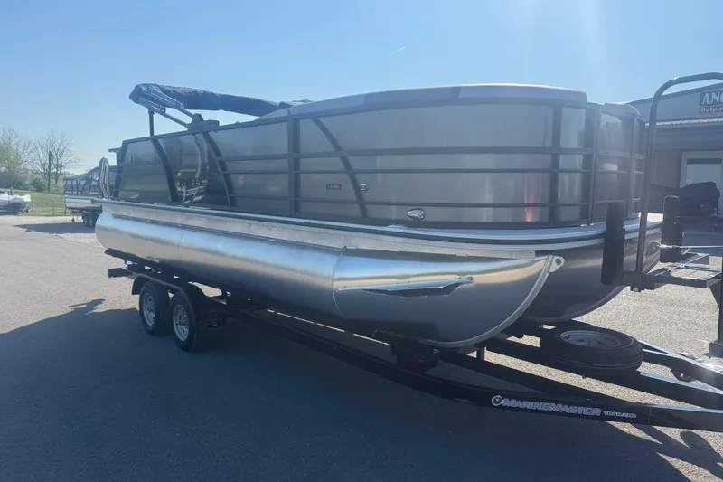 Slide: The Image of 2026 Trifecta 22ULCS pontoon boat on trailer, parked outdoors under sunlight. - 3