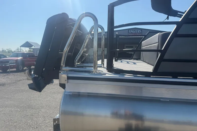 Slide: The Image of 2026 Trifecta 22ULCS pontoon boat rear view with motor and railing in sunlight. - 6