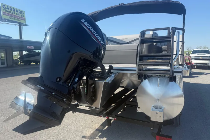 Slide: The Image of 2026 Trifecta 22ULCS pontoon boat with Mercury outboard motor at dealership. - 8