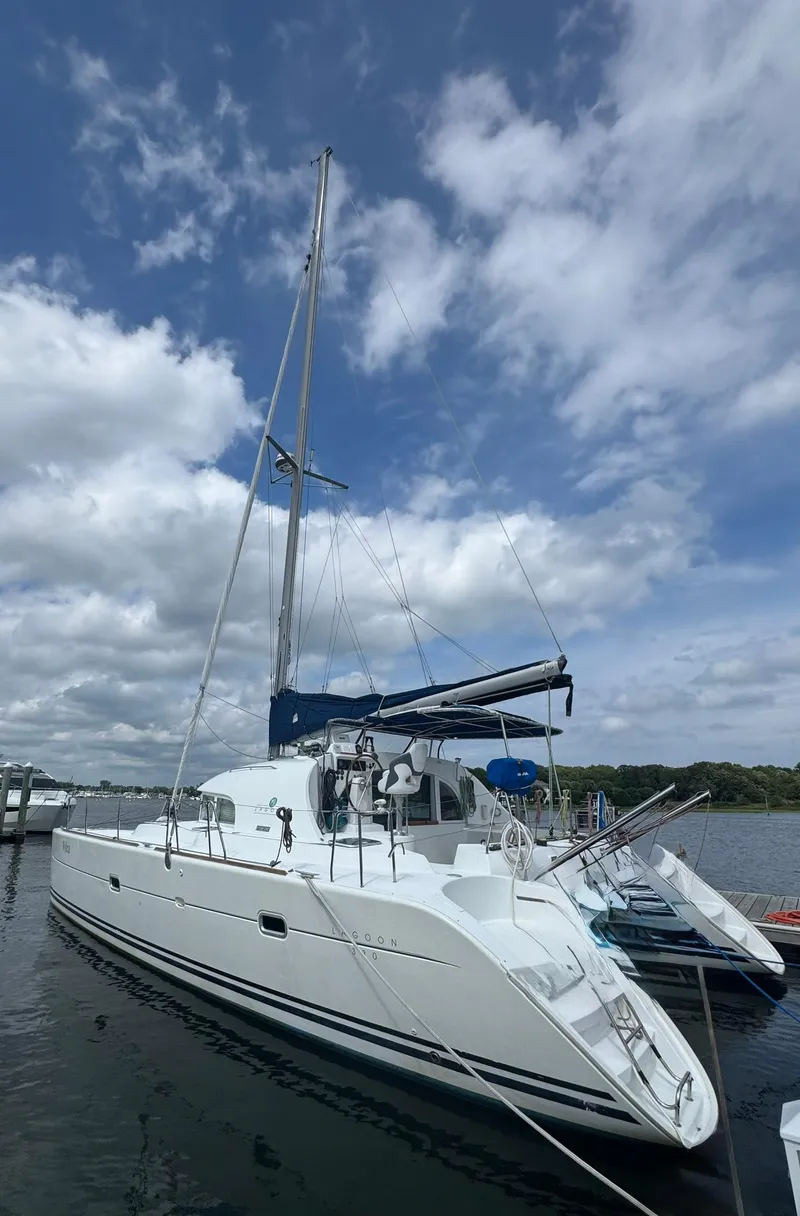 The Image of 2000 Lagoon 380 catamaran docked under a partly cloudy sky. - 1