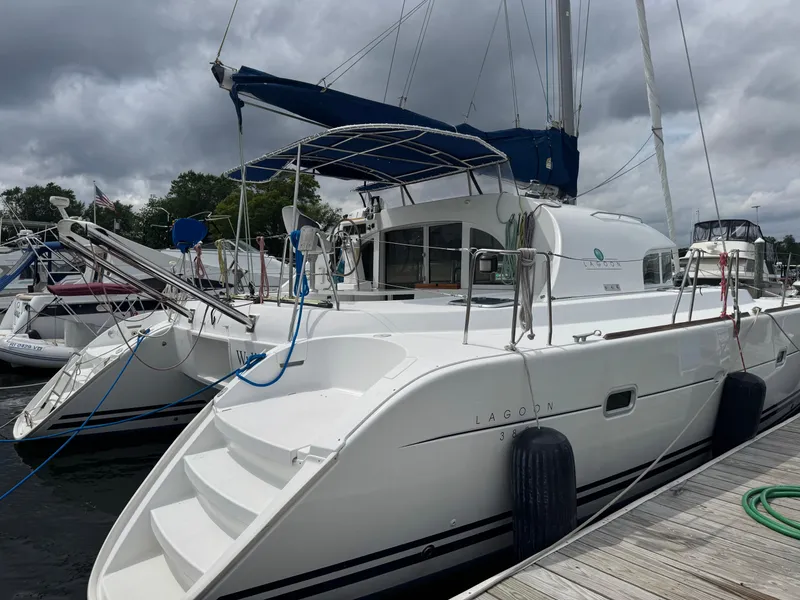 Slide: The Image of Lagoon 380 catamaran from 2000 docked at a marina under cloudy skies. - 2
