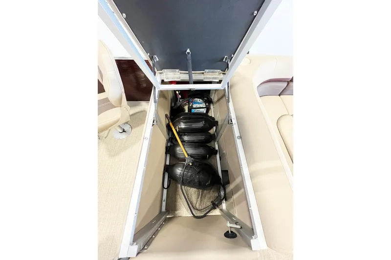 Slide: The Image of Open storage compartment in a 2020 Bennington SX25 boat, showing life jackets and equipment. - 16