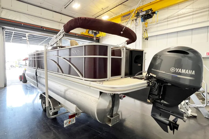 Slide: The Image of 2020 Bennington SX25 pontoon boat with Yamaha outboard motor in a garage setting. - 4
