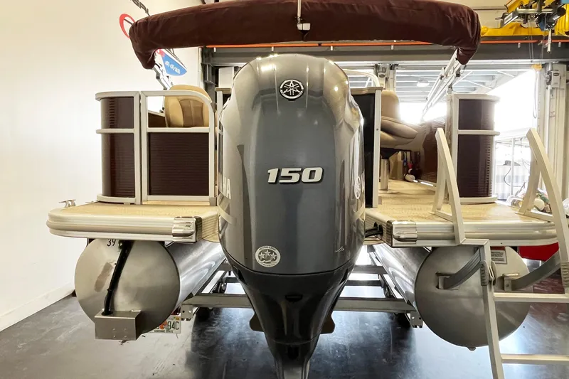 Slide: The Image of 2020 Bennington SX25 pontoon boat with Yamaha 150 outboard motor in a garage. - 5