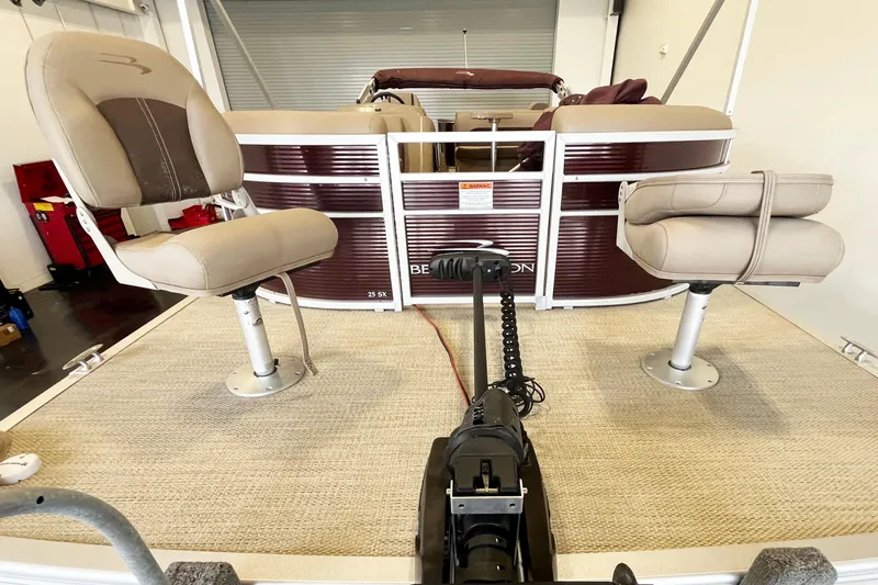 Slide: The Image of 2020 Bennington SX25 pontoon boat interior with beige seats and carpeted deck. - 6