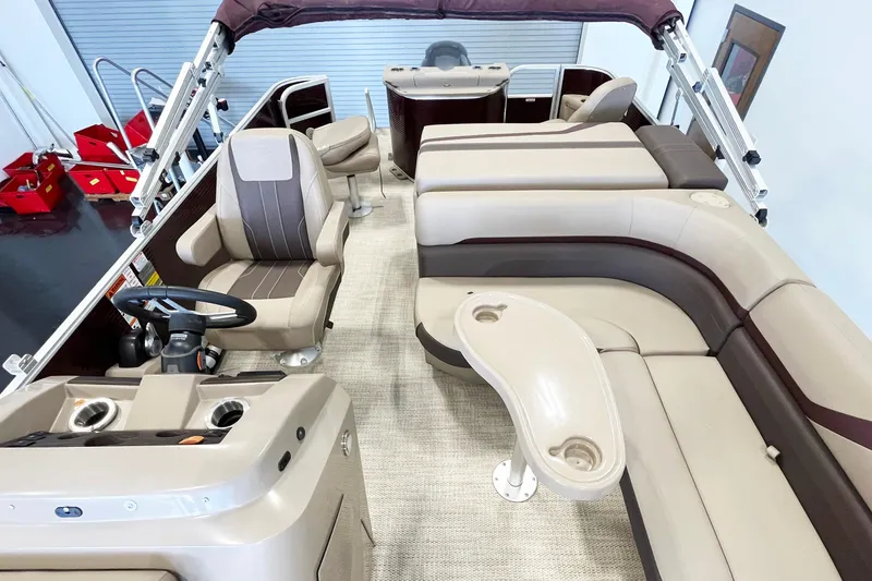 Slide: The Image of Interior of a 2020 Bennington SX25 pontoon boat with beige seating and steering console. - 7
