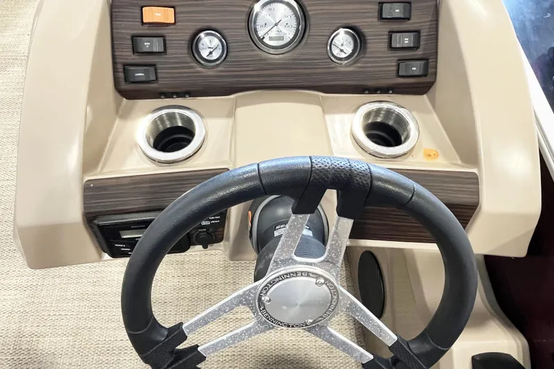 Slide: The Image of Steering wheel and dashboard of 2020 Bennington SX25 boat with controls and cup holders. - 8
