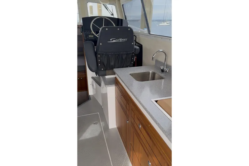Slide: The Image of Interior of 2026 Seaport Commander 2800 boat with helm seat and kitchenette. - 12