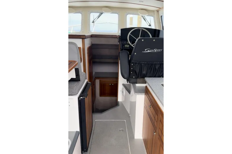 Slide: The Image of Interior of 2026 Seaport Commander 2800 boat with steering wheel and wooden cabinetry. - 13