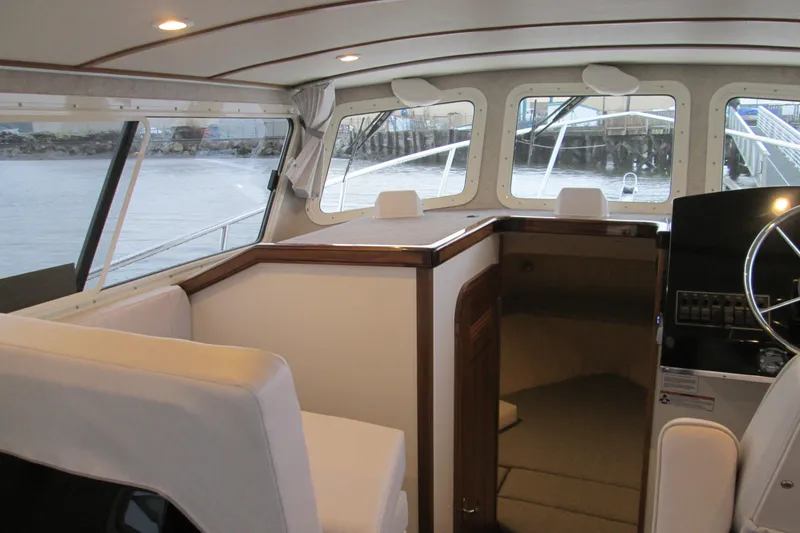Slide: The Image of Interior of 2026 Seaport Commander 2800 boat, featuring helm and seating area. - 18