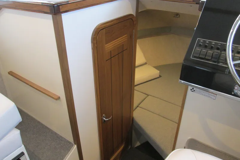Slide: The Image of Interior of 2026 Seaport Commander 2800 boat, featuring cabin door and helm controls. - 19