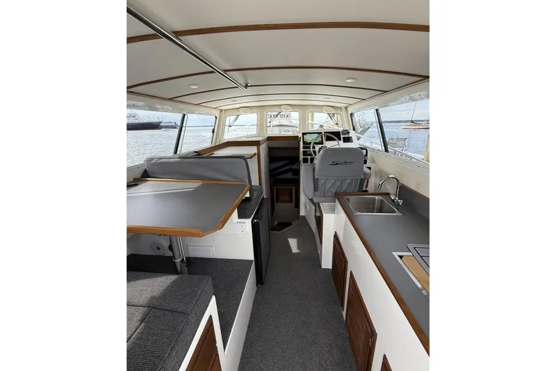 Slide: The Image of Interior of 2026 Seaport Commander 2800 boat, featuring modern seating and kitchenette. - 27