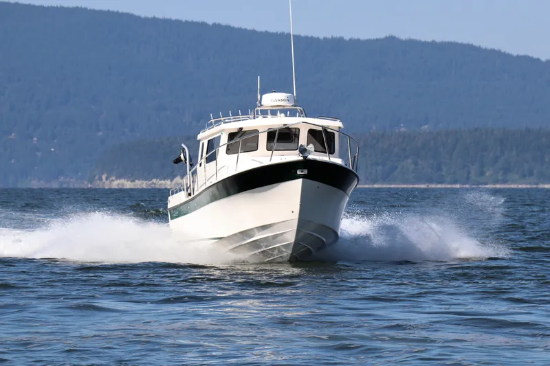 Slide: The Image of 2026 Seaport Commander 2800 cruising on open water with scenic mountain backdrop. - 3