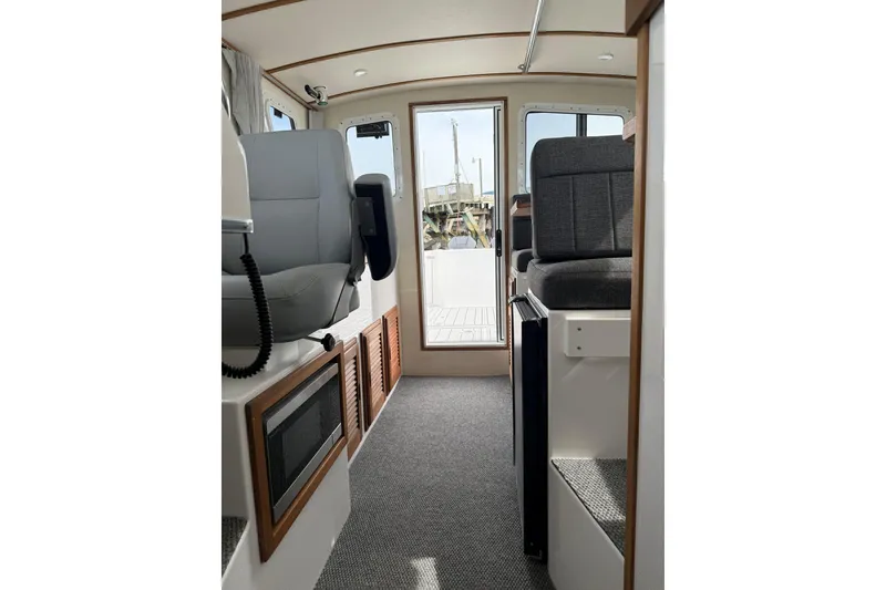Slide: The Image of Interior of 2026 Seaport Commander 2800 boat, featuring modern seating and carpeted flooring. - 8