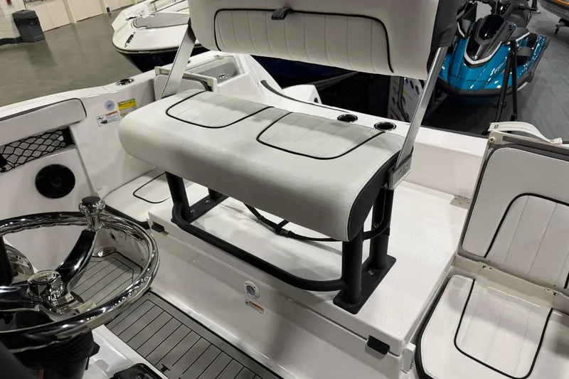 Slide: The Image of 2025 Yamaha Boats 222 FSH Sport E interior with white seating and steering wheel. - 22