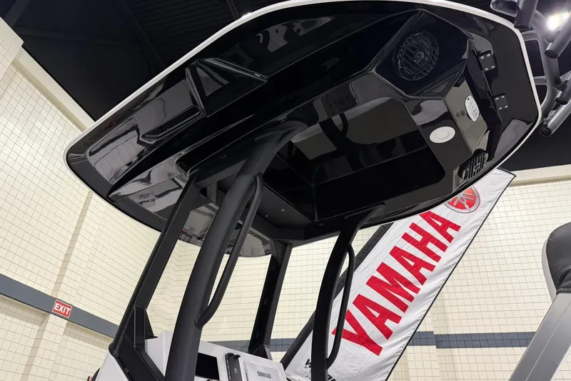 Slide: The Image of 2025 Yamaha Boats 222 FSH Sport E, black canopy, indoor display with Yamaha banner. - 27