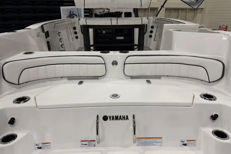 Slide: The Image of 2025 Yamaha Boats 222 FSH Sport E interior with white seating and cup holders. - 4