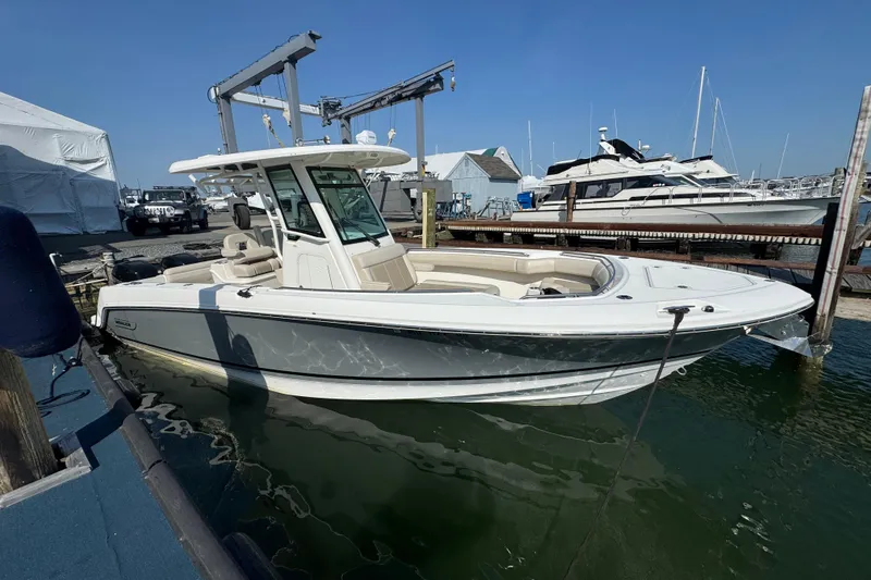 The Image of 2020 Boston Whaler 280 Outrage boat docked at marina, clear sky background. - 0