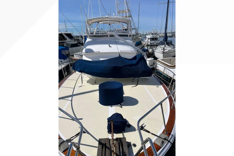 Slide: The Image of 1971 Pacifica 44 Convertible yacht docked at marina, covered seating area, clear sky. - 12