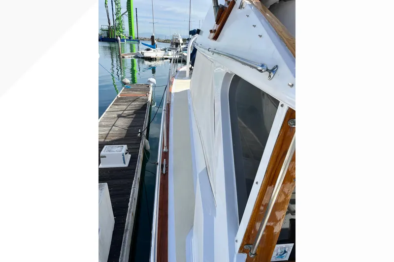 Slide: The Image of 1971 Pacifica 44 Convertible yacht docked at marina, showcasing sleek design and wooden accents. - 13