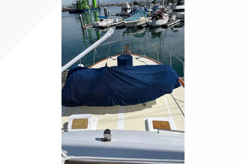 Slide: The Image of 1971 Pacifica 44 Convertible yacht docked at marina, covered deck, surrounded by boats. - 14