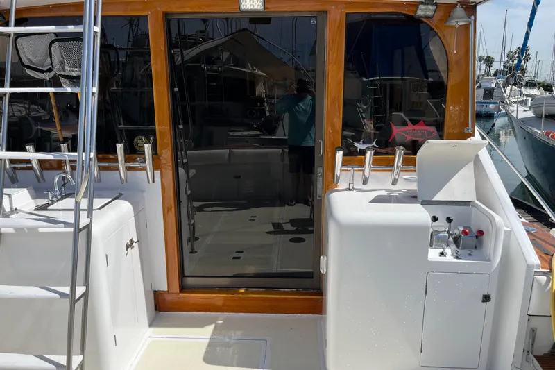 Slide: The Image of 1971 Pacifica 44 Convertible yacht deck with fishing equipment and ladder in marina. - 19