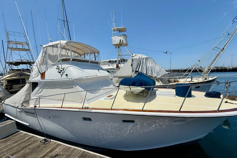 Slide: The Image of 1971 Pacifica 44 Convertible yacht docked at marina under clear blue sky. - 2