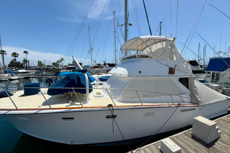 Slide: The Image of 1971 Pacifica 44 Convertible yacht docked at a marina under a clear blue sky. - 3