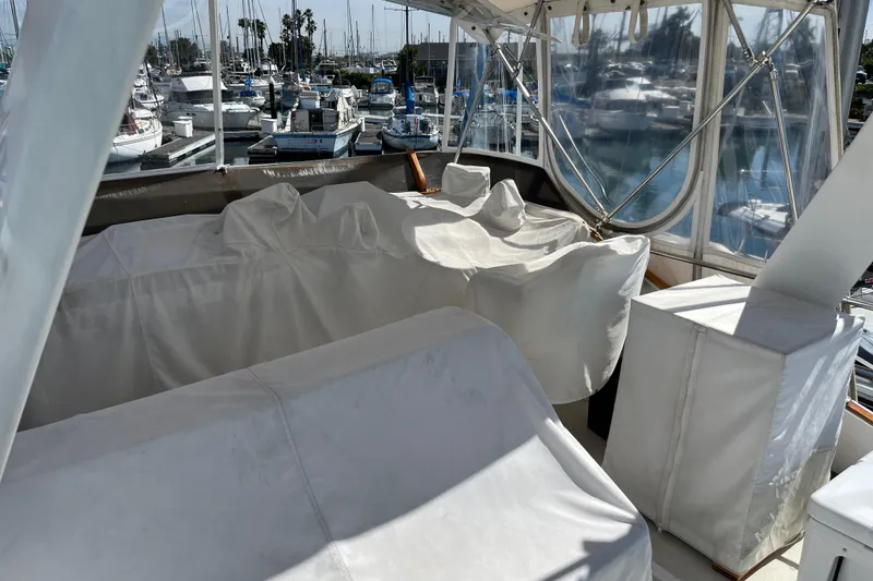 Slide: The Image of 1971 Pacifica 44 Convertible yacht interior with covered seating, docked at a marina. - 31