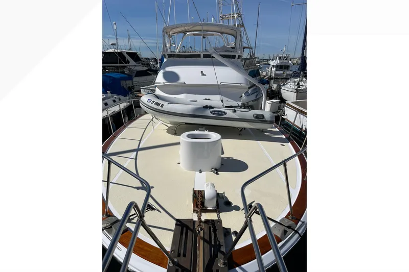 Slide: The Image of 1971 Pacifica 44 Convertible yacht docked, featuring spacious deck and inflatable boat. - 34