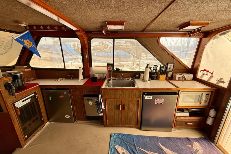 Slide: The Image of 1971 Pacifica 44 Convertible boat interior with kitchenette, featuring sink, fridge, and utensils. - 39