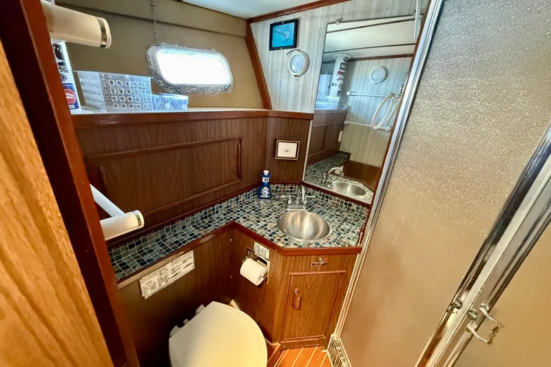 Slide: The Image of Interior of a 1971 Pacifica 44 Convertible yacht featuring a bathroom and wooden cabinetry. - 46