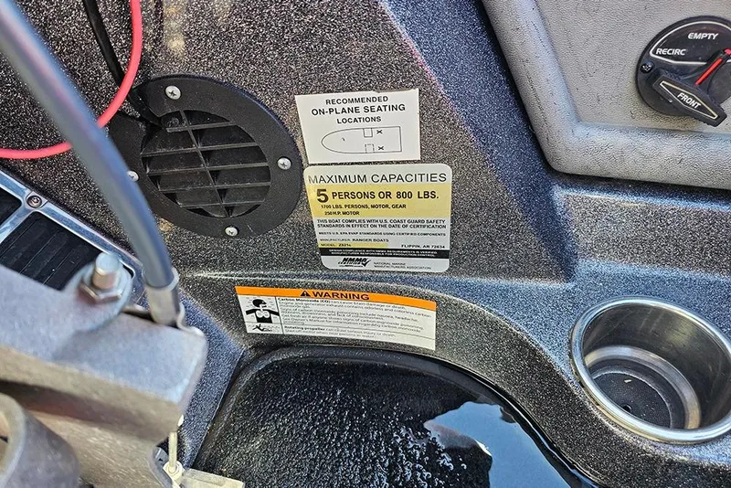 Slide: The Image of 2015 Ranger Z521 Comanche boat dashboard with capacity and safety warnings. - 23