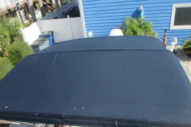 Slide: The Image of Blue canvas cover on 1998 Grady-White Adventure 208 boat, near blue house and greenery. - 27