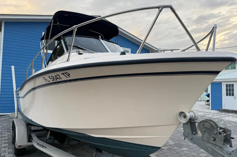 Slide: The Image of 1998 Grady-White Adventure 208 boat on trailer, parked near blue building. - 3