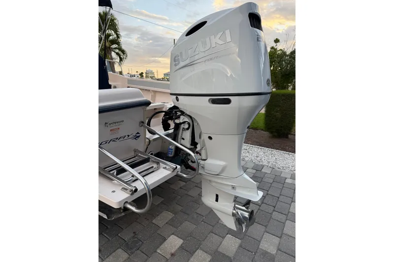 Slide: The Image of 1998 Grady-White Adventure 208 with Suzuki outboard motor on a paved driveway. - 9