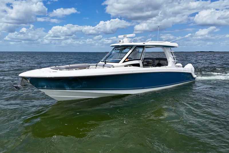 The Image of 2025 Boston Whaler 350 Realm boat cruising on open water under a partly cloudy sky. - 0
