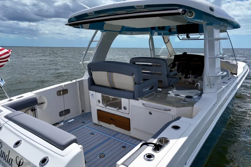 Slide: The Image of 2025 Boston Whaler 350 Realm boat interior with seating and helm, on open water. - 10