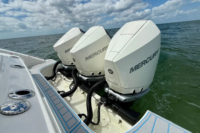 Slide: The Image of 2025 Boston Whaler 350 Realm with triple Mercury outboard engines on open water. - 11