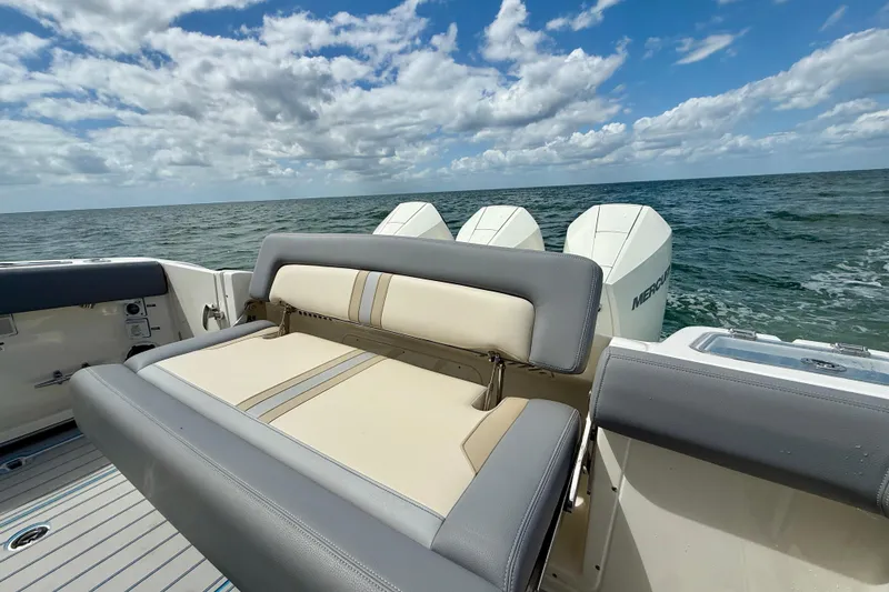 Slide: The Image of 2025 Boston Whaler 350 Realm boat with cushioned seating, ocean view, and outboard motors. - 14