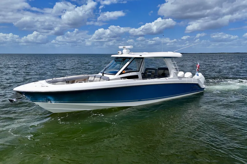 Slide: The Image of 2025 Boston Whaler 350 Realm boat cruising on open water under a partly cloudy sky. - 2