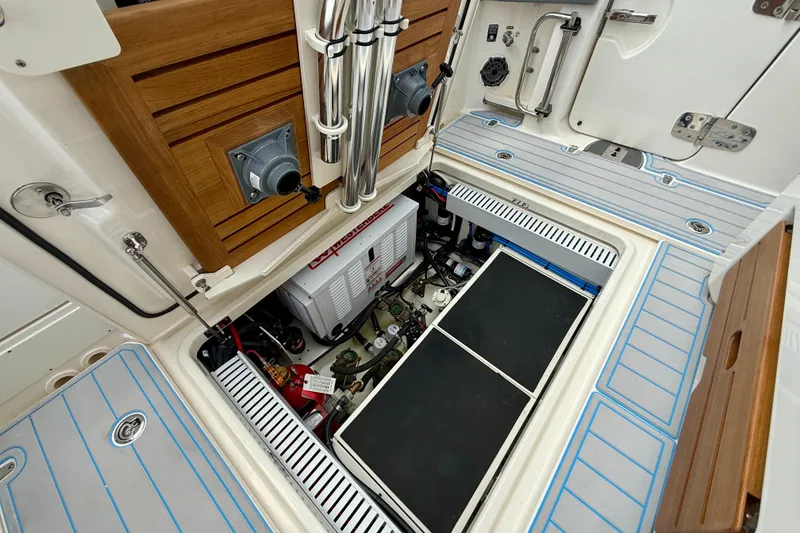 Slide: The Image of Engine compartment of 2025 Boston Whaler 350 Realm, showcasing mechanical components and storage. - 25
