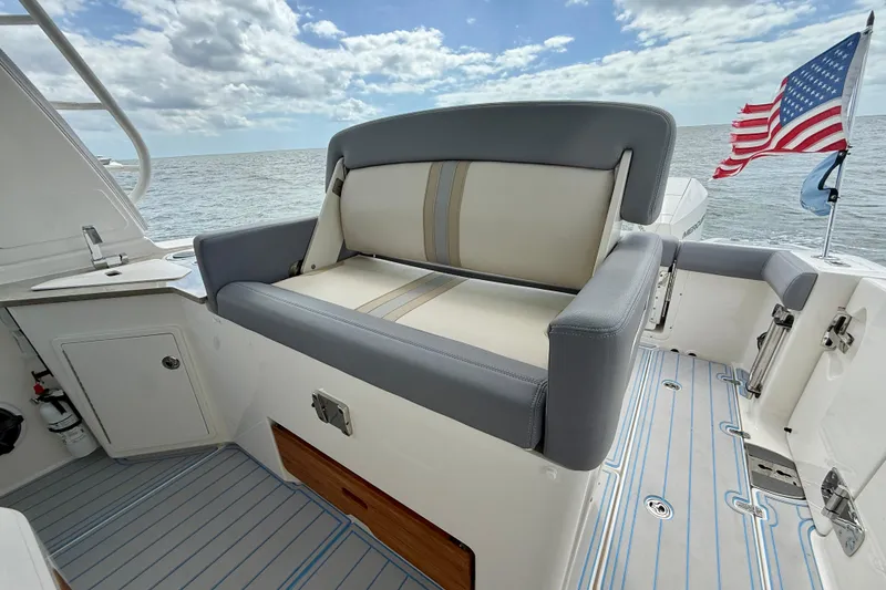 Slide: The Image of Boston Whaler 350 Realm 2025 boat interior with seating and American flag. - 28