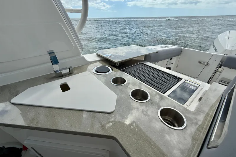 Slide: The Image of Boston Whaler 350 Realm 2025 boat kitchen area with grill and ocean view. - 29