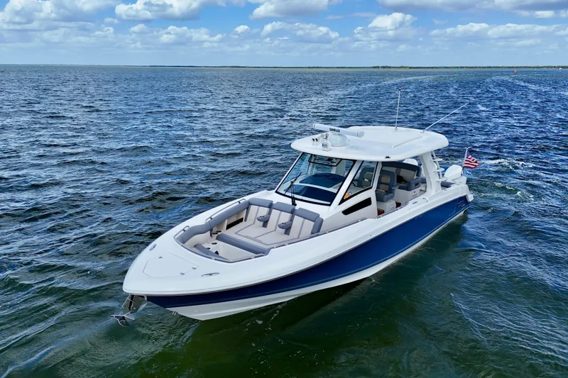 Slide: The Image of 2025 Boston Whaler 350 Realm boat cruising on open water under a cloudy sky. - 3